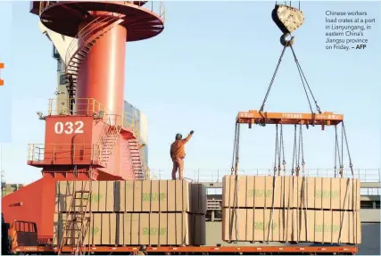  ?? — AFP ?? Chinese workers load crates at a port in Lianyungan­g, in eastern China’s Jiangsu province on Friday.