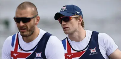  ??  ?? Tom George, right, prepares to compete in the heats at the European Rowing Championsh­ips