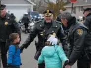  ??  ?? Brad Fox Jr., left and Kadence Fox, right, run to greet police officers Tuesday morning as they show up to their home to visit and deliver a holiday meal.