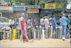  ??  ?? People wait to refill oxygen cylinders at Bhogal near Jangpura on Tuesday.