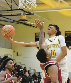  ?? BARBARA HADDOCK TAYLOR/BALTIMORE SUN ?? Parkville’s Josiah Legree attempts a layup over New Town’s Jaleel Hawkins during the second half of Friday night’s game.