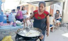  ??  ?? Teresa López Suárez coordina a 14 mujeres debajo de un árbol de almendra para preparar los alimentos.