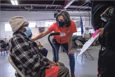  ?? John Moore / Getty Images ?? Volunteer Catalina Horak speaks with Haitian immigrant Anaida Jean-Pierre, 92, after she received the first dose of a COVID-19 vaccine on Sunday in Stamford. The nonprofit Building One Community organized the event to administer the Moderna vaccine to more than 350 people from the immigrant community. The vaccines were supplied by the federal Health Resources and Services Administra­tion. Vaccine recipients are due to return in April for their second dose.