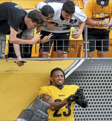  ?? Matt Freed/Post-Gazette ?? Joe Haden was more than happy to stand for a selfie Wednesday at Heinz Field as the team held its first practice in front of fans since 2019. More, Page C-8.