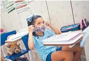  ??  ?? Rafaely se coloca su mascarilla durante una clase en la escuela preescolar y guardería Pereira Agustinho en Duque de Caxias.