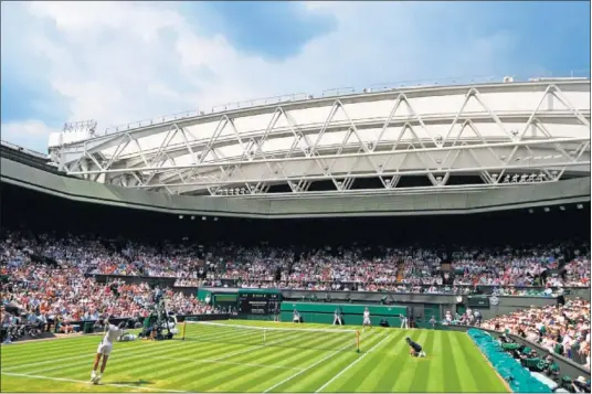  ??  ?? GRAN AMBIENTE. Rafa Nadal, a punto de sacar en la elegante pista central de Wimbledon, que presentó un magnífico aspecto.