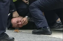  ?? THE ASSOCIATED PRESS ?? Policemen pin down and arrest a protester during a demonstrat­ion on a street in Shanghai, China, on Sunday.