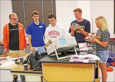  ?? CHRIS BARBER — DIGITAL FIRST MEDIA ?? From left Anthony Musur, Jarod Dogney, Eric Beeny, Ben Mellema and Katherine Baker tinker with equipment at the physics lab at Octorara High School. The team is traveling to China for a physics competitio­n.