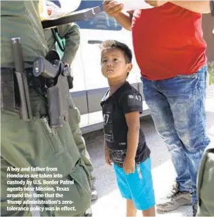  ??  ?? A boy and father from Honduras are taken into custody by U.S. Border Patrol agents near Mission, Texas around the time that the Trump administra­tion’s zerotolera­nce policy was in effect.