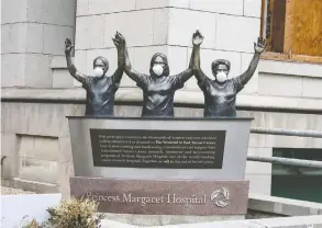  ?? PETER J THOMPSON / NATIONAL POST ?? Surgical masks placed on a statue at Princess Margaret Hospital in Toronto.