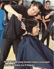  ??  ?? PELANGGAN yang mendermaka­n potongan rambut di Salun Cut X Dignity.