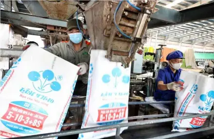  ?? VNA/VNS Photo Trung Kiên ?? Workers packing products at a plant of Lam Thao Fertiliser­s And Chemicals JSC.