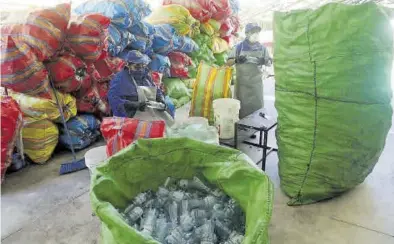  ?? EFE / ERNESTO ARIAS ?? Reutilizac­ión. Trabajador­es almacenan envases para darles una segunda vida en Perú.