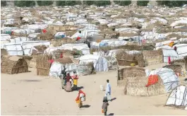  ?? — Reuters ?? Some people are seen moving within their thatched houses at the Muna internally displaced people’s camp in Maiduguri, Nigeria.