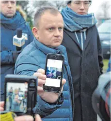  ?? FOTO: DPA ?? Ariel Zurawski, Eigentümer der Spedition im polnischen Dorf Sobiesmysl, zeigt den Journalist­en ein Bild seines Cousins, das angeblich nur wenige Stunden vor dessen Tod gemacht wurde.