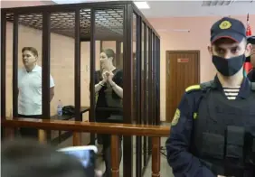  ?? FOTO: RAMIL NASIBULIN/AP/TT ?? ■
Aktivisten Maria Kolesnikov­a och advokaten Maksim Znak i rätten i Minsk i september 2021. Bägge två dömdes till mångåriga fängelsest­raff för sina roller i protestern­a 2020.