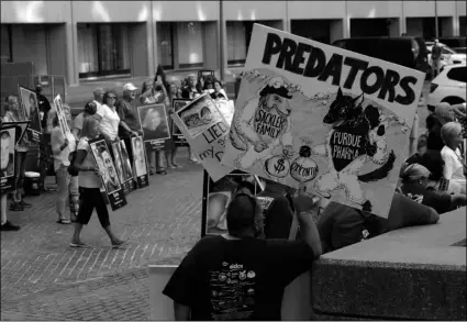  ??  ?? Protesters gather outside a courthouse on Friday, in Boston, where a judge was to hear arguments in Massachuse­tts’ lawsuit against Purdue Pharma over its role in the national drug epidemic. AP PHOTO/CHARLES KRUPA