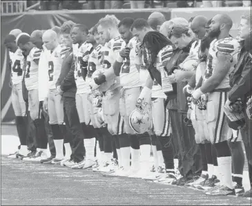  ??  ?? Dallas Cowboys players hang their heads Sunday during a moment of silence honouring teammate Jerry Brown, who was killed in an automobile accident early Saturday, prior to their game against the Bengals in Cincinnati.