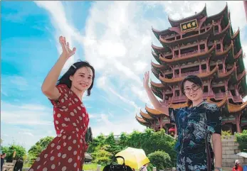  ?? XIAO YIJIU / XINHUA ?? Visitors enjoy the springtime at the Yellow Crane Tower, a popular tourist attraction in Wuhan, Hubei province. Local residents are gradually recovering from the losses caused by the pandemic.