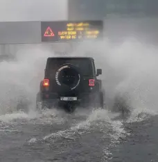  ?? Pawan Singh / The National; Andy Scott / The National ?? Left, a rainbow colours a rainy day in Dubai. Above, heavy going for Dubai traffic