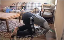  ??  ?? NEW HOME: Sarhan Aldobai prays in his living room. On his first afternoon there, a man arrived with a compass to locate the direction of Mecca.