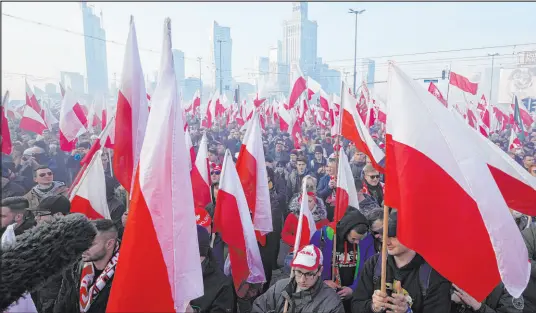  ?? Czarek Sokolowski The Associated Press ?? People hold Polish flags during the annual Independen­ce Day march Thursday in Warsaw, Poland.