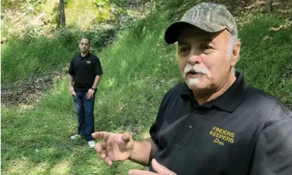  ?? Photograph: Michael Rubinkam/AP ?? Dennis Parada, right, and his son stand at the site of the FBI's dig for cvil war-era gold in Dents Run, Pennsylvan­ia, in September 2018.