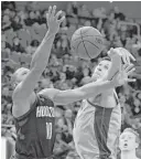  ?? Carlos Osorio / Associated Press ?? Pistons center Boban Marjanovic, right, swats the ball away from Rockets guard Eric Gordon. Marjanovic had a pair of blocked shots in the game.