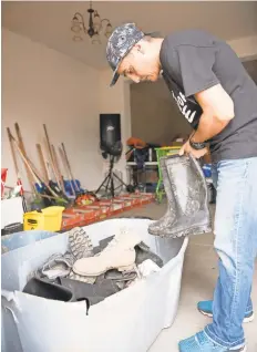  ?? JASPER COLT/USA TODAY ?? Pastor Humberto “Bert” Pizarro looks for his rubber boots before heading out to perform hurricane relief work in Arecibo.