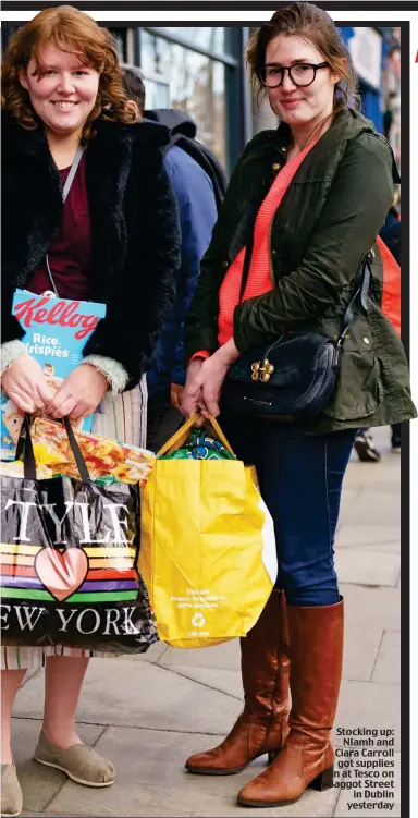  ??  ?? Stocking up: NIamh and Ciara Carroll got supplies in at Tesco on Baggot Street in Dublin yesterday