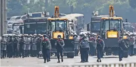  ?? (AFP) ?? Armed police personnel advance towards protesters, in Myanmar’s largest city Yangon on Monday