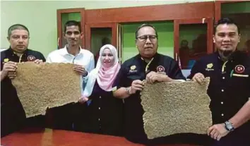  ??  ?? DR Mohamad Shahrum (dua dari kanan) menunjukka­n sampel produk getah piawaian baharu yang dinamakan crepe rubber.