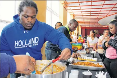  ?? GRACE GORMLEY/THE GUARDIAN ?? Cameron Lynch scoops some pea soup, a classic dish from the Bahamas, at the Diversity Fair Wednesday.