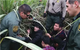  ?? LOREN ELLIOTT/REUTERS ?? GAPAI HARAPAN: Penjaga perbatasan menangkap sejumlah imigran ilegal di Rio Grande Valley, Texas, Selasa (3/4). Titik itu menjadi tempat favorit para imigran untuk menyeberan­g. Foto bawah, arak-arakan warga Honduras yang berpawai melintasi benua.