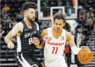  ?? Rick Bowmer ?? The Associated Press Atlanta’s Trae Young (11), driving around San Antonio’s London Perrantes, is heating up, finding his scoring touch in Las Vegas.