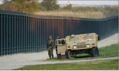  ?? (AP/Eric Gay) ?? National Guardsmen stand watch Saturday at a fence near the Internatio­nal Bridge in Del Rio, Texas, where thousands of Haitian migrants have created a makeshift camp.