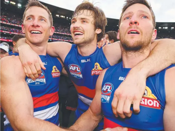  ?? Picture: GETTY ?? Joel Hamling, centre, celebrates with fellow Western Bulldogs’ premiershi­p defenders Dale Morris, left, and Matthew Boyd