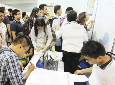  ?? ABS-CBN ?? Filipinos line up to check openings during a job fair at SM Mall of Asia, in this May 2014 photo. A recent Social Weather Stations survey showed that more Filipinos are jobless and are pessimisti­c that there will be more available jobs.