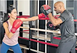  ??  ?? GLOVE
STORY
Anna Magee taking a breather at The Secret Boxing Gym in London, main; and training with coach Richard Williams, left