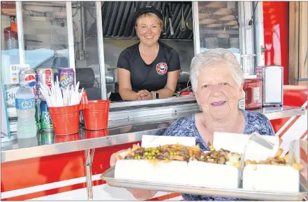  ?? ERIC MCCARTHY/JOURNAL PIONEER ?? Up West Fire Fries owner Kelly Wilson looks on as Noreen Gaudet from Harper Road heads off with her tray of fresh-cut, fresh-cooked fries.