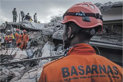  ?? ULET IFANSASTI
GETTY IMAGES ?? An Indonesian search and rescue team looking for victims at a collapsed mosque following an earthquake in Tanjung on August 7 in Lombok Island, Indonesia. At least 105 people have been confirmed dead after a earthquake hit the Indonesian island, Lombok.