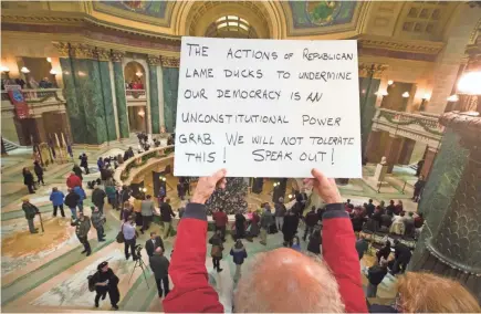  ?? MARK HOFFMAN / MILWAUKEE JOURNAL SENTINEL ?? People protest the Legislatur­e's extraordin­ary session during the official Christmas tree lighting ceremony Tuesday at the Capitol in Madison. The Legislatur­e is considerin­g measures to limit the powers of Gov.-elect Tony Evers and Attorney General-elect Josh Kaul when they take office.