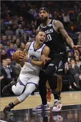  ?? RICH PEDRONCELL­I — THE ASSOCIATED PRESS ?? Warriors guard Stephen Curry, left, drives against Sacramento Kings center Willie CauleyStei­n during the first quarter Saturday night in Sacramento.