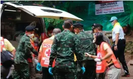  ??  ?? Left: Thai soldiers outside the quarantine tent in the Tham Luang cave area where the rescued boys were checked. Right: Soldiers and paramedics carry a rescued boy on a stretcher to an ambulance. Photos: Getty Images