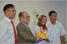  ??  ?? Aini presents a souvenir to Uggah as Bujang (left) and Sabah corporate figure Datuk Yap Yun Fook (right) look on.