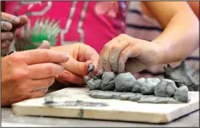  ?? FILE PHOTO/DAVID GOTTSCHALK ?? The hands of Jacqueline Katsuren, kindergart­en teacher at Sonora Elementary School, and Talia Wright, a kindergart­en student, are visible as they create a clay caterpilla­r at the Community Creative Center. Summer camps start June 5 at the Walton Arts...