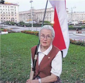  ?? FOTO: ULF MAUDER/DPA ?? Nina Baginskaja steht auf dem Unabhängig­keitsplatz an der katholisch­en Roten Kirche mit ihrer selbst genähten weiß-rotweißen Fahne. „Die Deutschen sind Hitler losgeworde­n. Wir schaffen das mit diesem Diktator auch“, sagt die 73-Jährige.