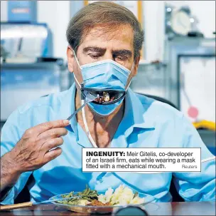  ?? Reuters ?? INGENUITY: Meir Gitelis, co-developer of an Israeli firm, eats while wearing a mask fitted with a mechanical mouth.