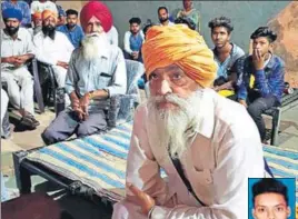  ?? SAMEER SEHGAL/HT ?? Rajinder Singh (R), father of the missing man Amarjit Singh (inset), surrounded by fellow residents at Naranjanpu­r village in Amritsar on Sunday.