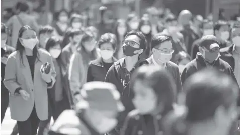  ?? AGENCE FRANCE PRESSE ?? People wear masks on a street in Hong Kong on February 27, 2023 as health experts in the territory backed the extension of its mask mandate to March 8 leaving Hong Kong as one of the only places left in the world with such rules.